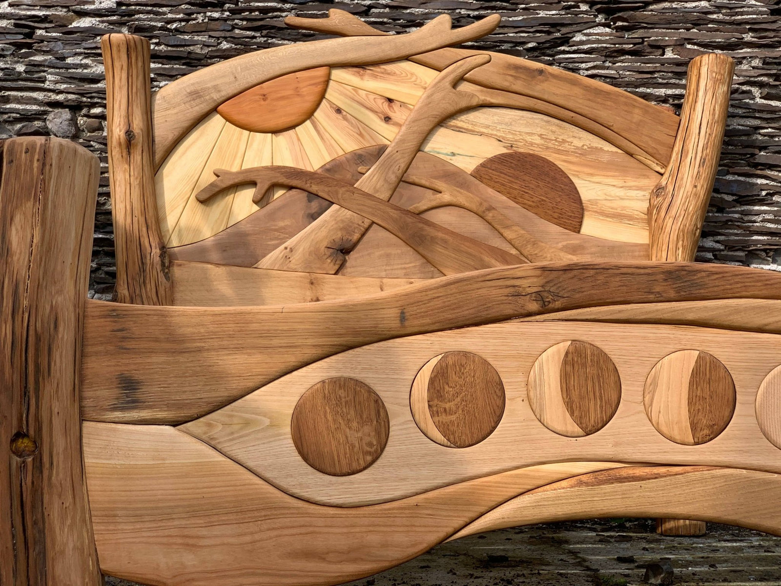 Curved solid oak Sunrise Bed with carved sunrise motif — bespoke, handmade Wales
