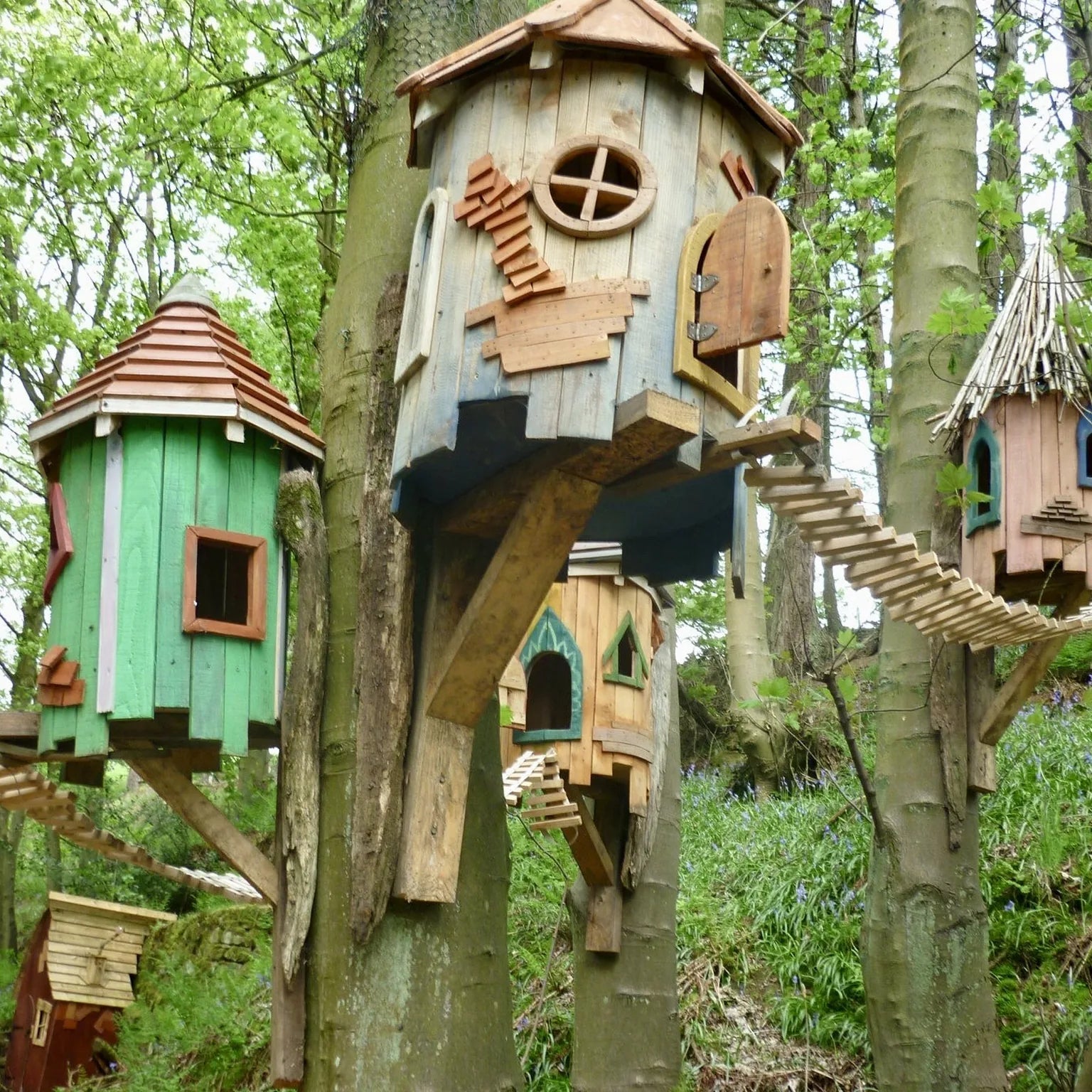 Detail view of tree fairy house roof and upper structure with bark-on branches and natural timber finish