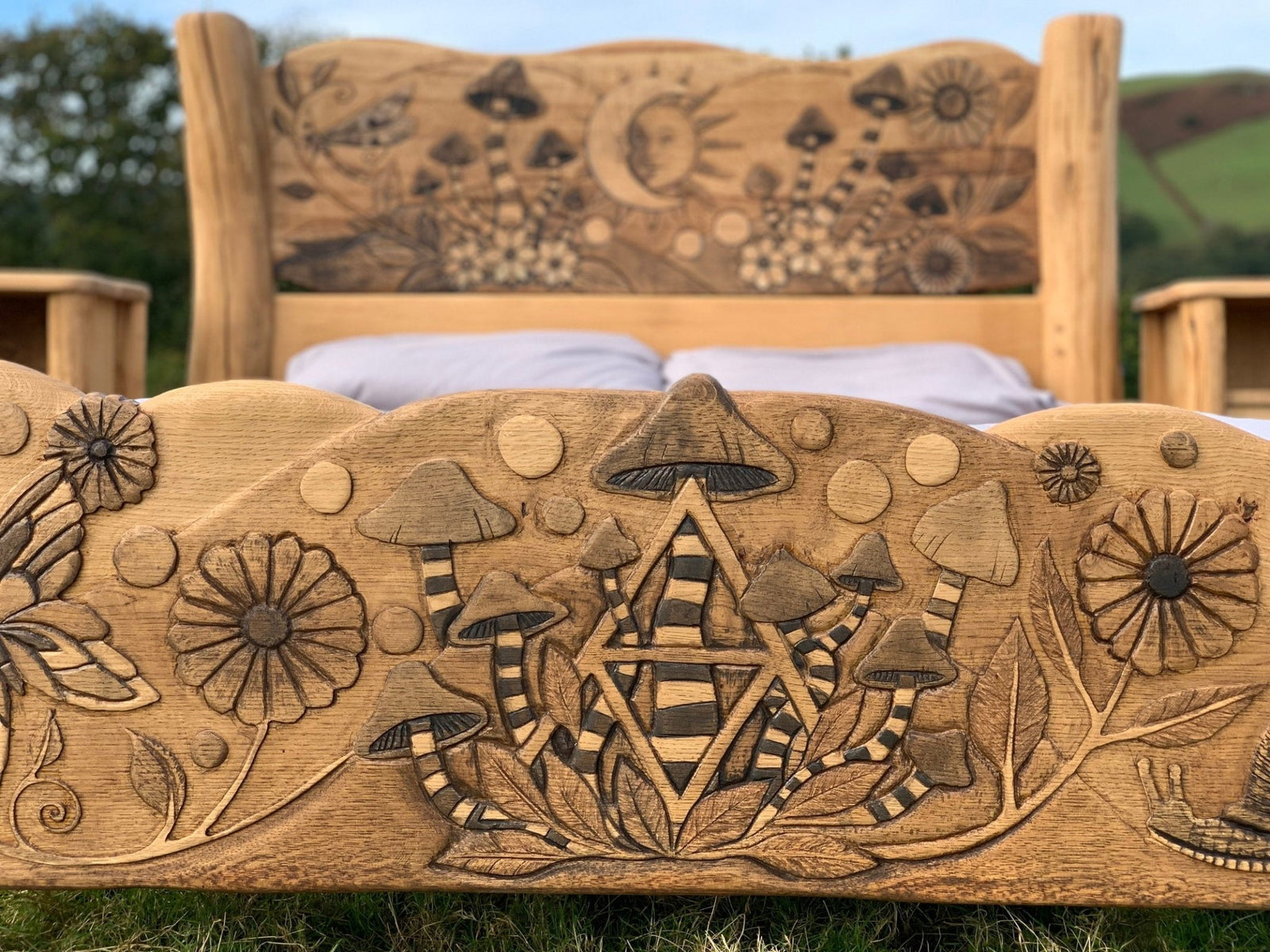 Footboard with mushroom and geometric carvings on bespoke solid oak fantasy bed — handmade Wales