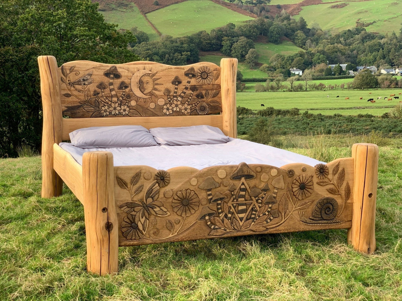 Rustic solid oak fantasy bed with nature carvings in Welsh landscape — handmade in Wales