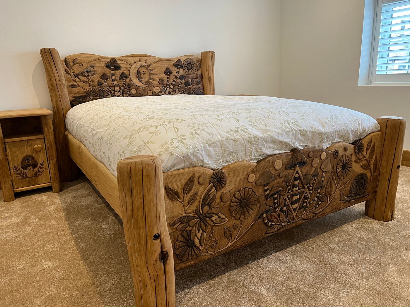 Solid oak fantasy bed with intricate hand-carved designs in bedroom — bespoke, handmade Wales