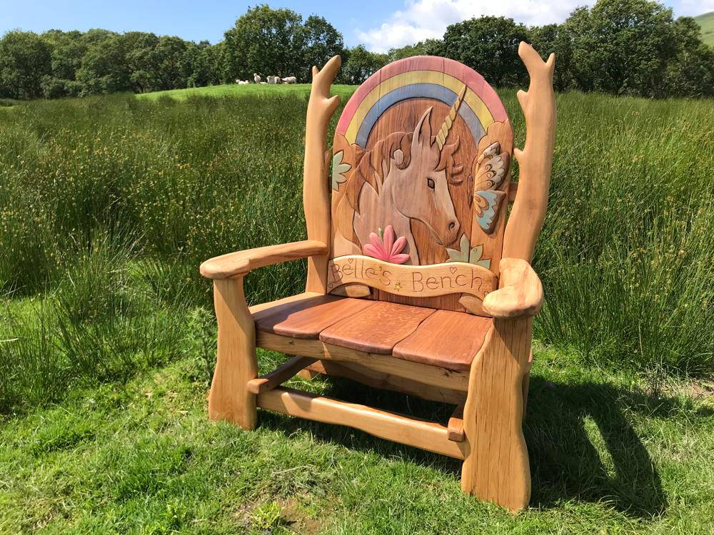 Carved unicorn detail on handmade solid oak memorial bench — bespoke tribute seating, Wales