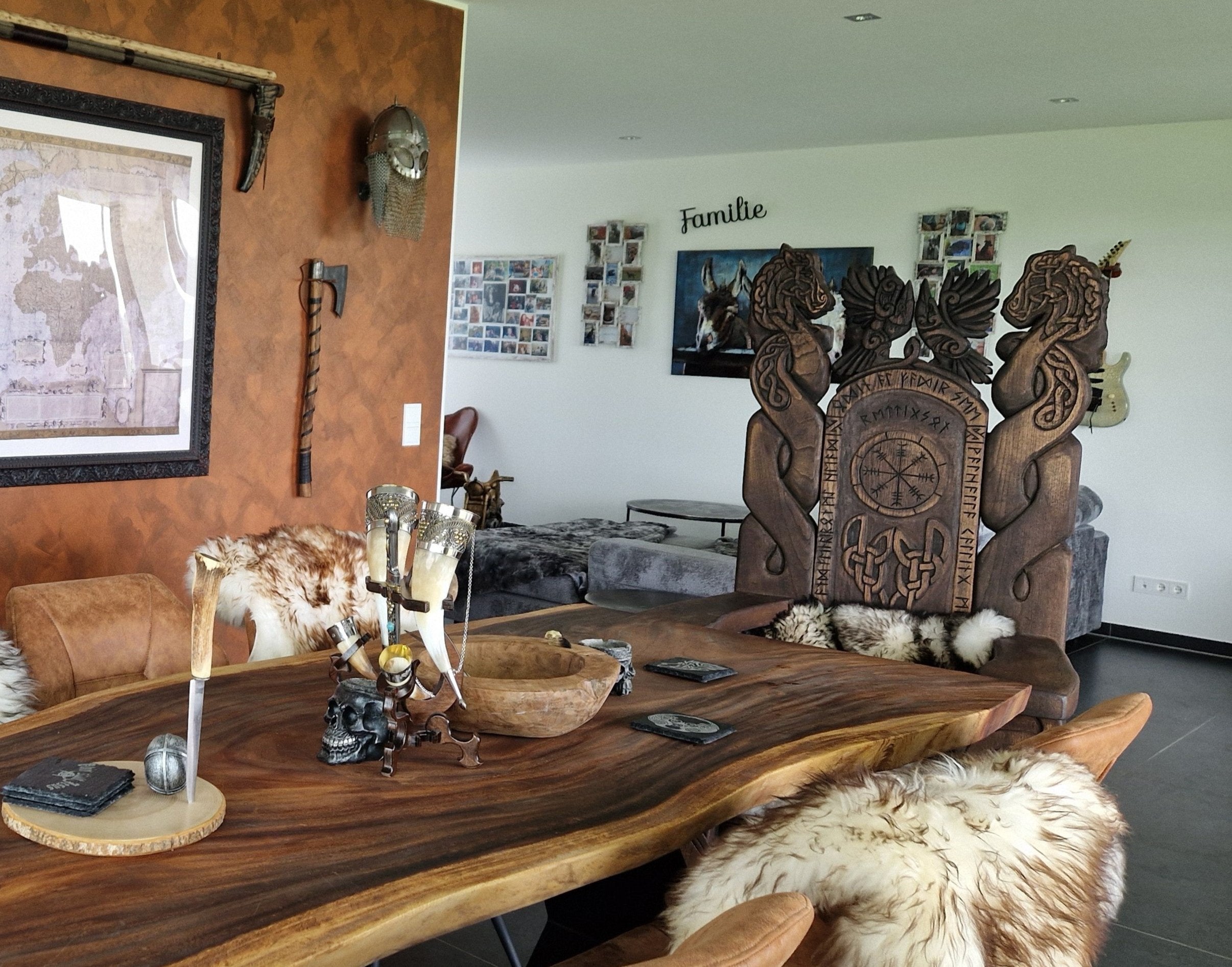 Viking-inspired dining room with a handcrafted throne chair featuring Norse designs, a live edge wooden table, and rustic decor elements, creating a medieval aesthetic