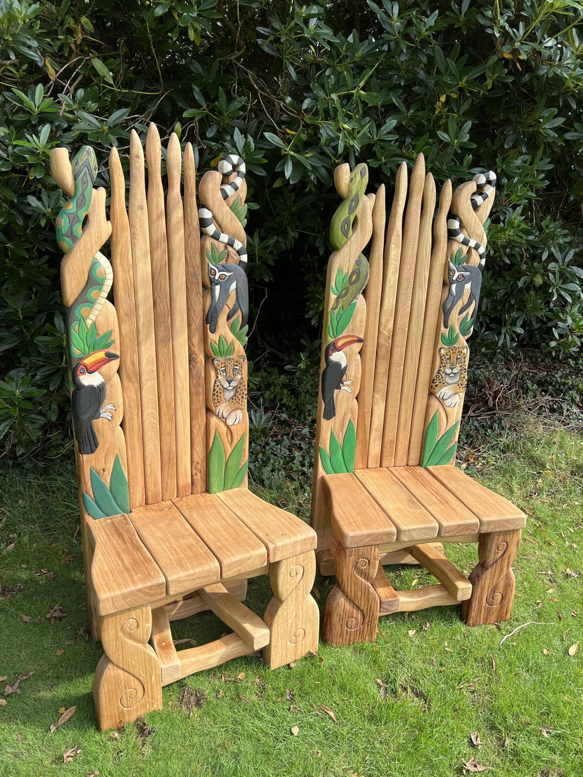 Close-up of jungle-inspired carved oak throne — toucan, jaguar and lemur details, handmade Wales