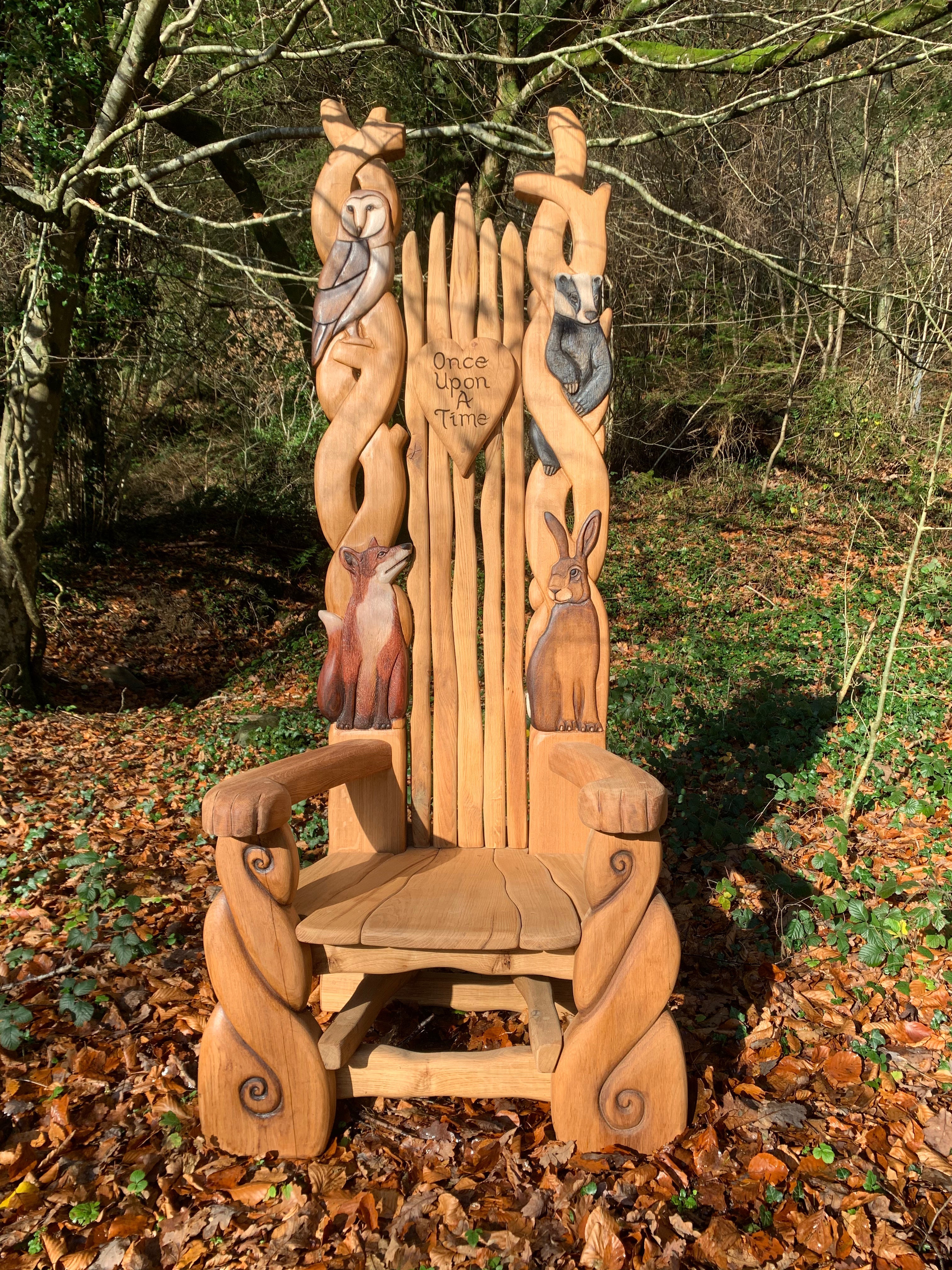 Chaise en bois avec des sculptures d'animaux dans une forêt.