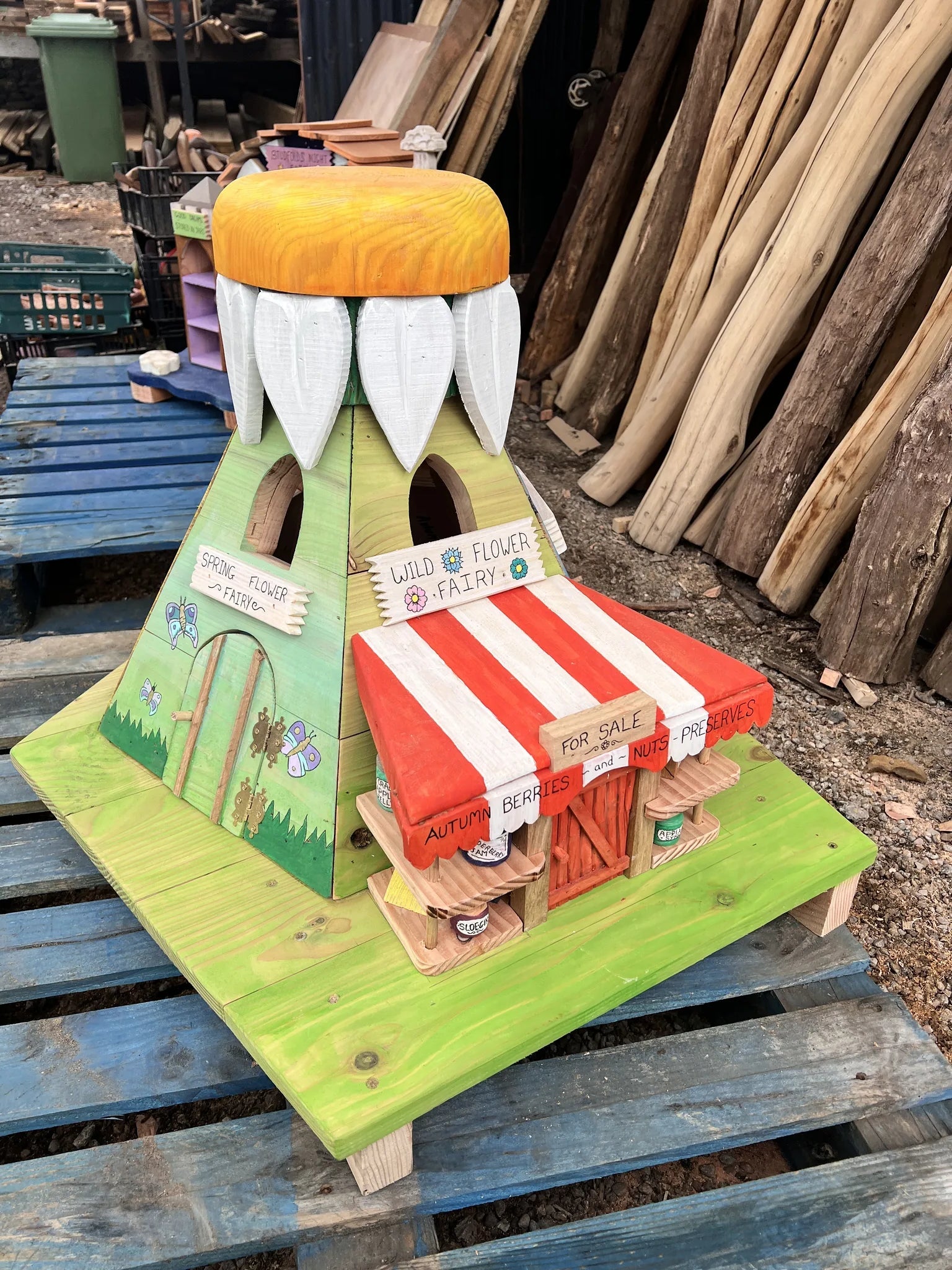 Close-up of wildflower fairy house showing hand-painted floral and seasonal market stall details