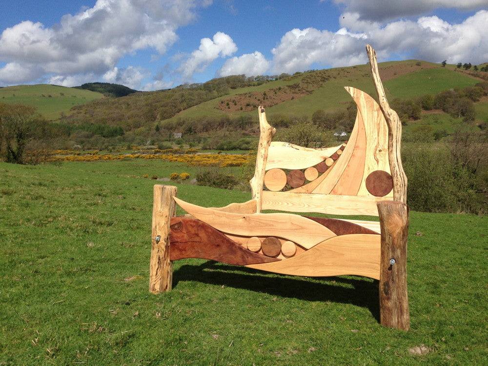 Unique driftwood bed frame in scenic landscape