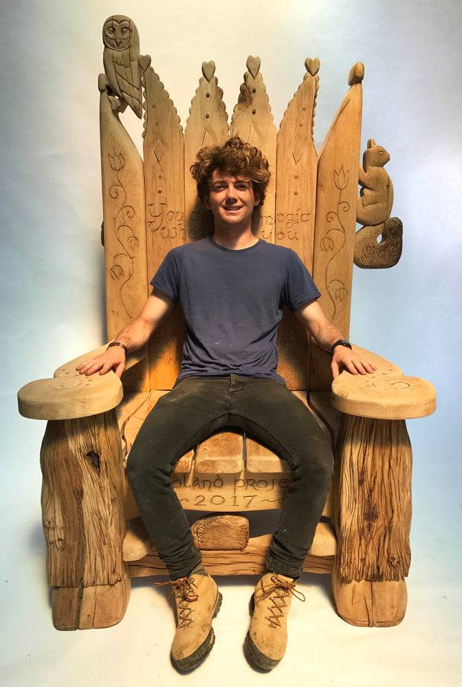 Child seated on handcrafted carved oak woodland storytelling chair — bespoke reading throne, Wales