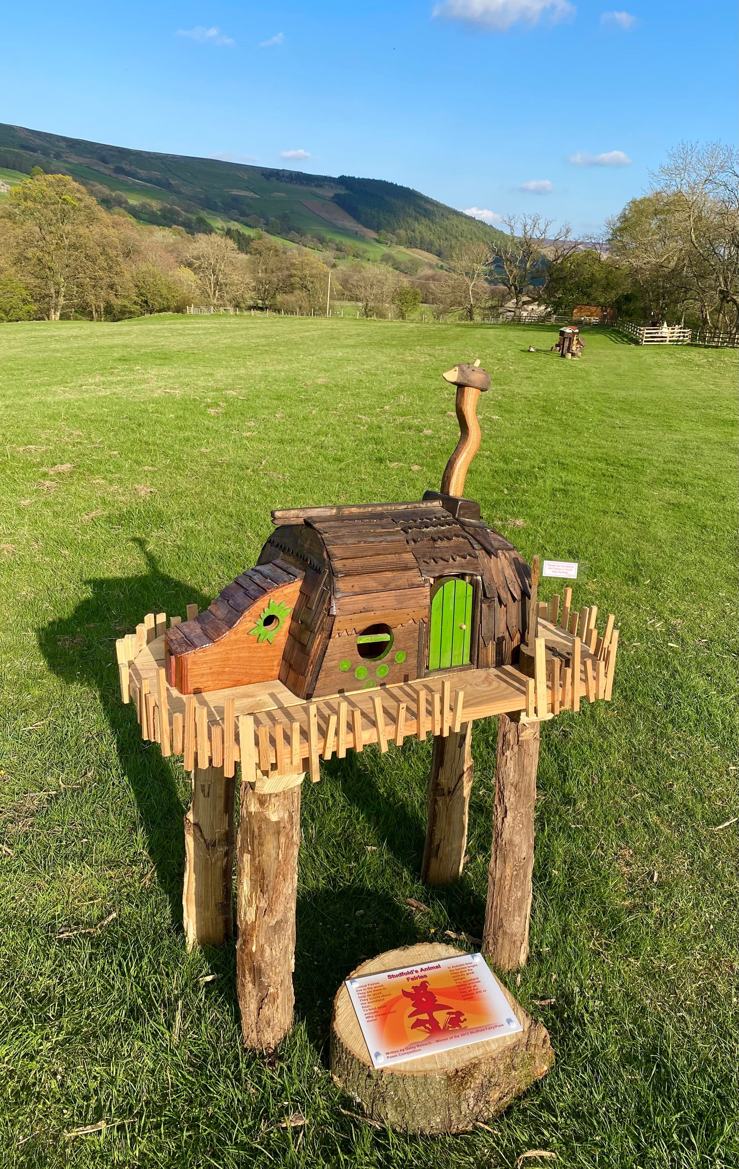 Rustic fairy house on wooden stilts in a field