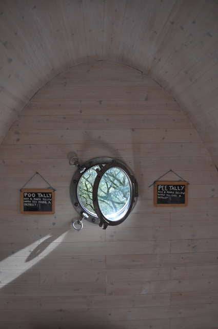 Rundes Fenster im Inneren der Timber Arc Composting Toilet