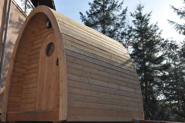 Vue latérale de la toilette à compost Timber Arc dans son environnement naturel