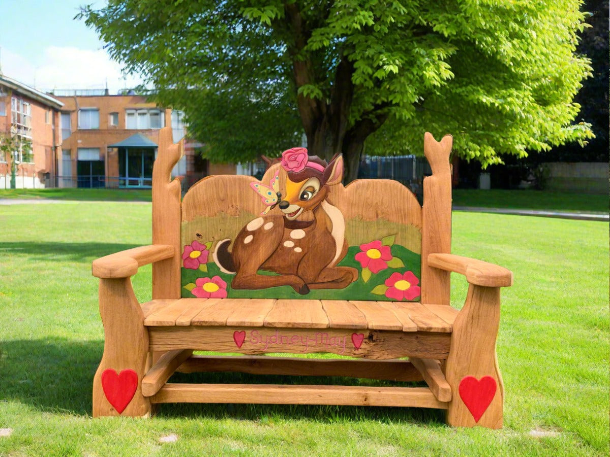 Outdoor oak bench with Bambi motif in garden setting