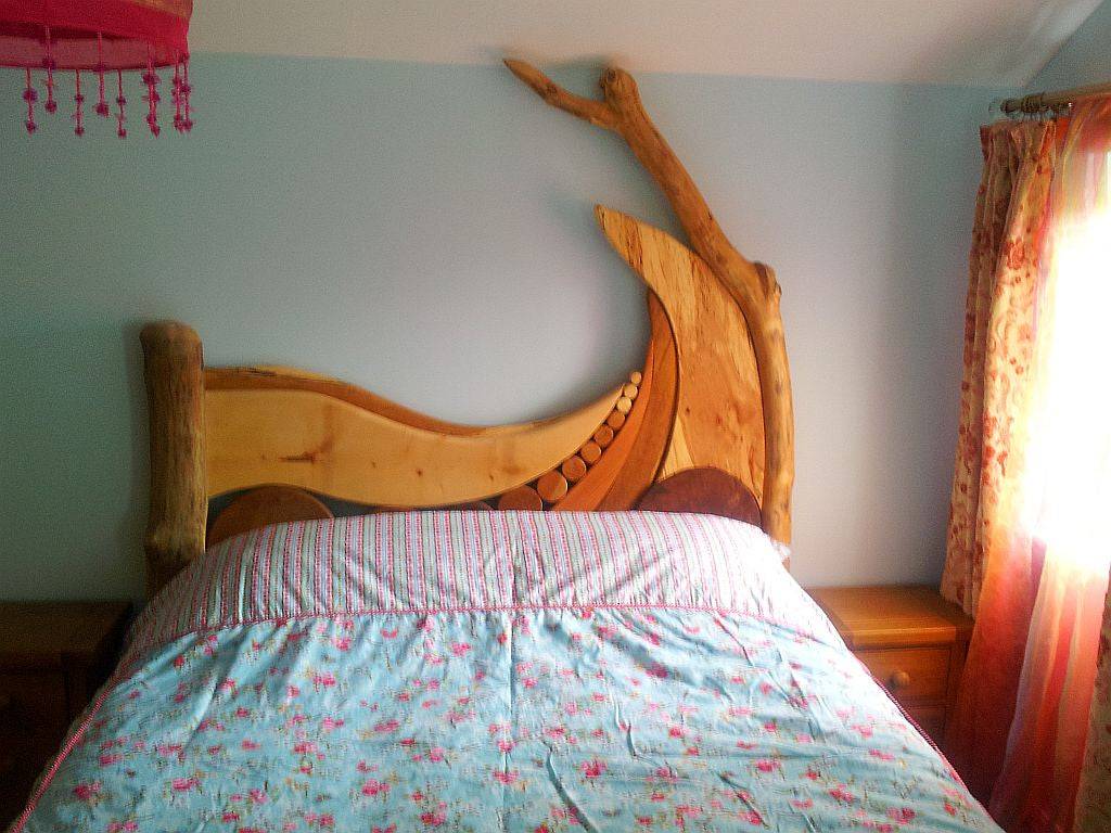 Wooden bed with floral bedding in bright room