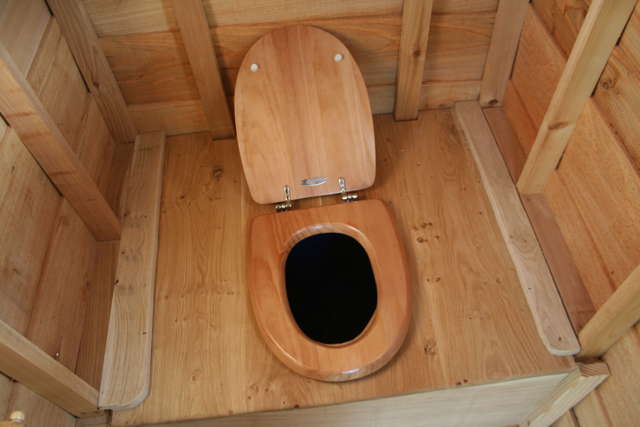 Wooden toilet seat inside compost toilet