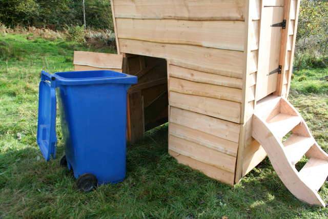 Vue arrière de la toilette à compost Gypsy avec la poubelle bleue