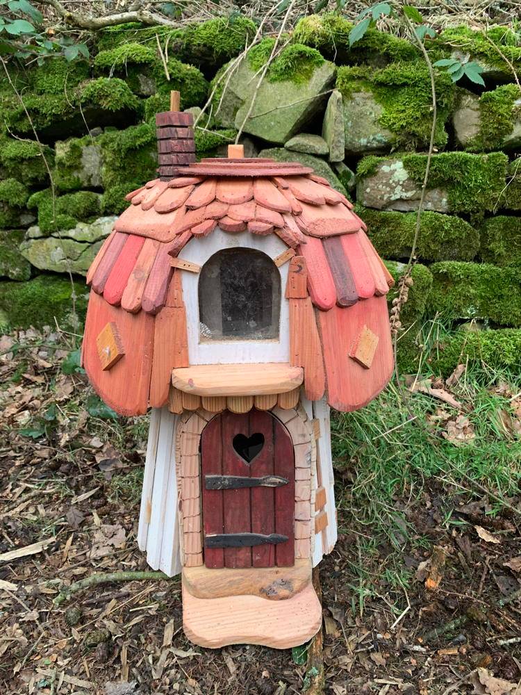 Fairy house with red roof and heart-shaped door