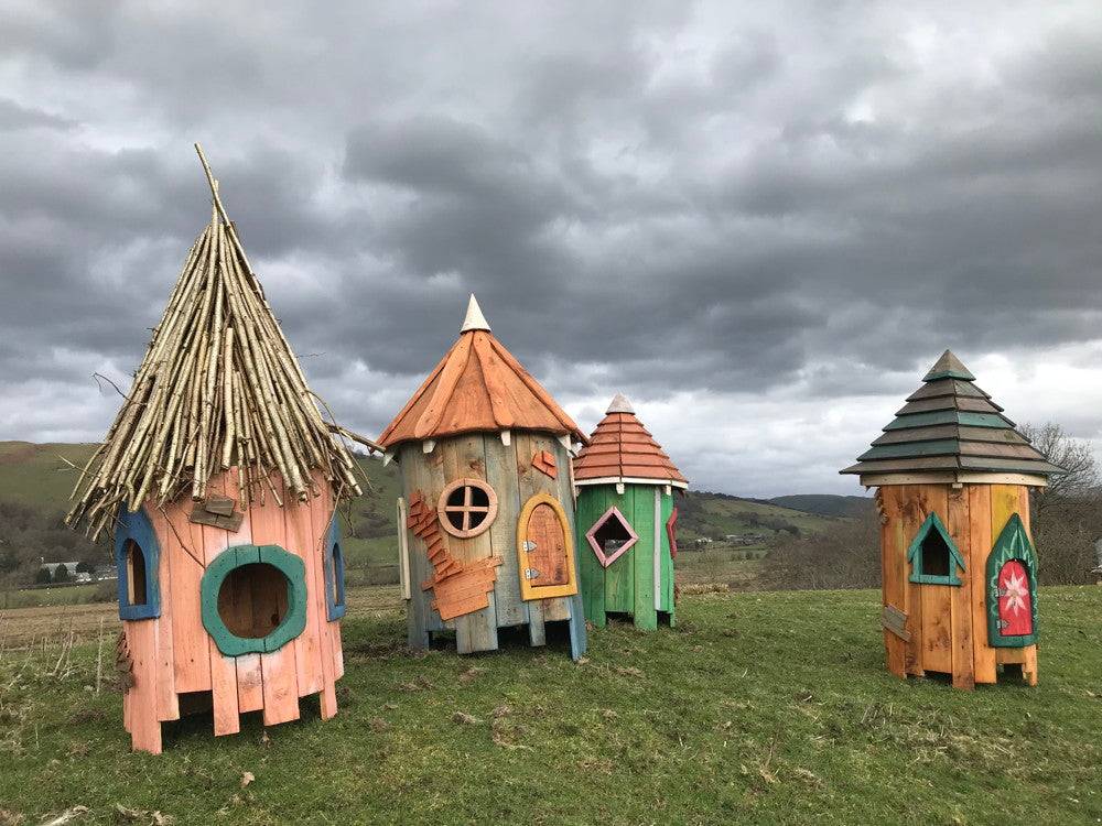 Fairy houses with unique roofs in an open field