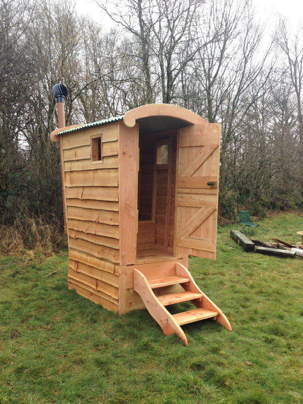 Hölzerne Komposttoilette mit offener Tür auf dem Feld