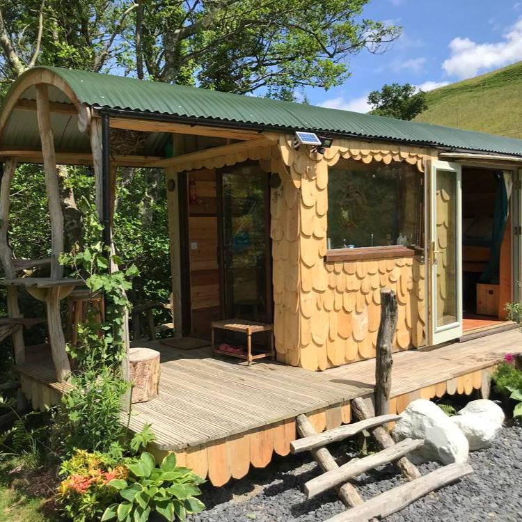 Cabane du berger avec terrasse en bois et environnement luxuriant