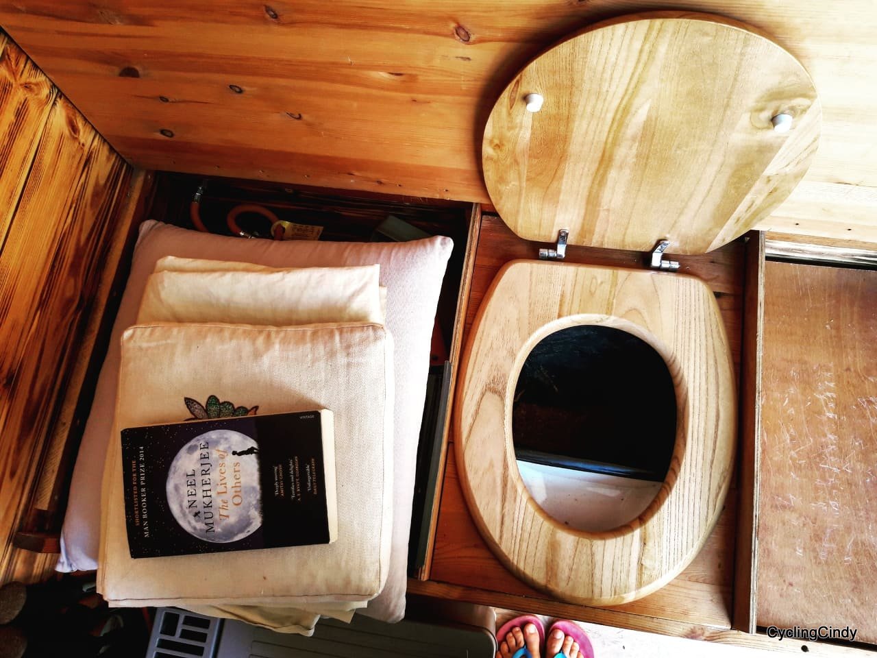 Composting toilet setup with wooden seat and urine diverter.